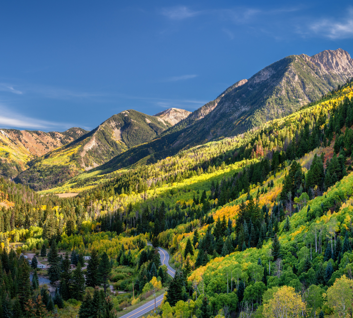 Mountain valley with a road and river running through it.